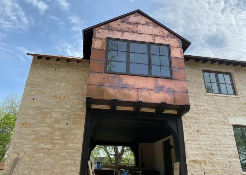 Copper metal panel facade on a stone building for Roof Repair in Groveton