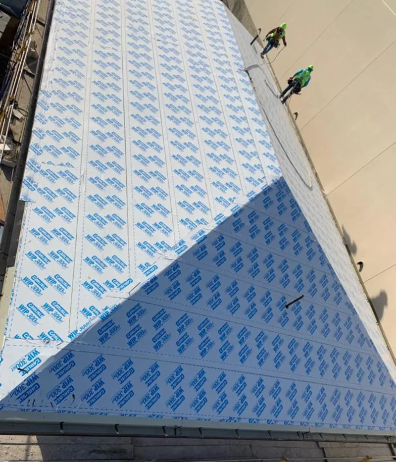 Professional roofers installing underlayment on a metal roof in Groveton